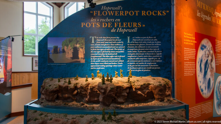 Three-dimensional model of Hopewell flowerpot rocks beneath a bilingual interpretive panel in the visitor centre.