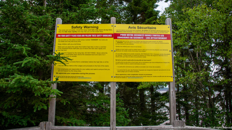 Bilingual yellow Safety Warning sign for visitors entering the Hopewell Rocks tidal shore.