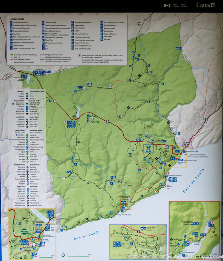 Large Fundy National Park map with green park area, roads, trails, facility symbols, coastline, legend, and inset maps.