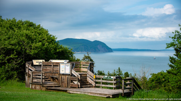 Wooden Herring Cove overlook with interpretive panels facing a forested headland and the Bay of Fundy.