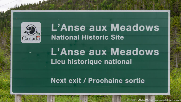 Green bilingual Parks Canada road sign for L’Anse aux Meadows National Historic Site stating “Next exit.”