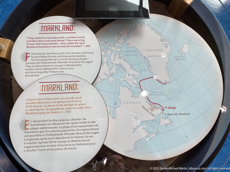 Circular interpretive map labeled Markland with red route from Greenland toward northeastern North America and L’Anse aux Meadows.