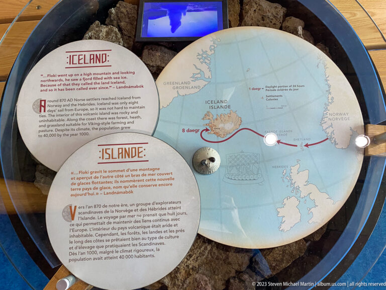 Circular North Atlantic map with Iceland highlighted and a red voyage route, beside bilingual Iceland interpretive text.