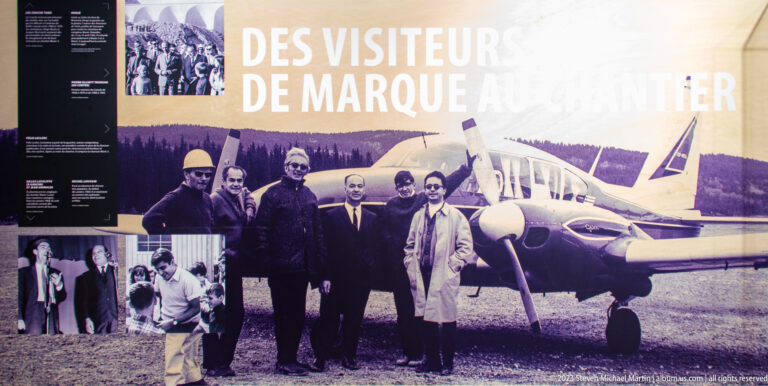 Historical exhibit showing a group of visitors beside a small aircraft, with archival photos and French text.