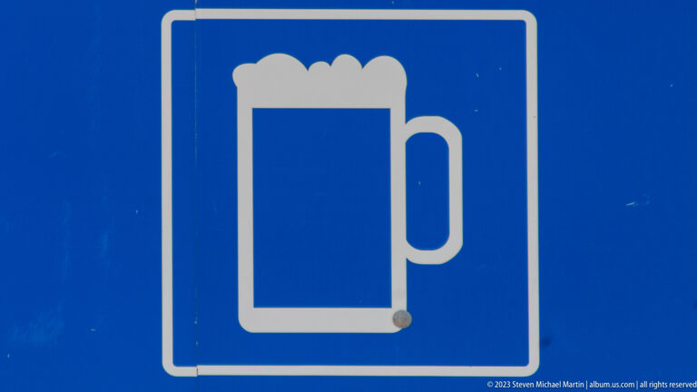 Blue rectangular service sign with a large white pictogram of a foaming beer mug.