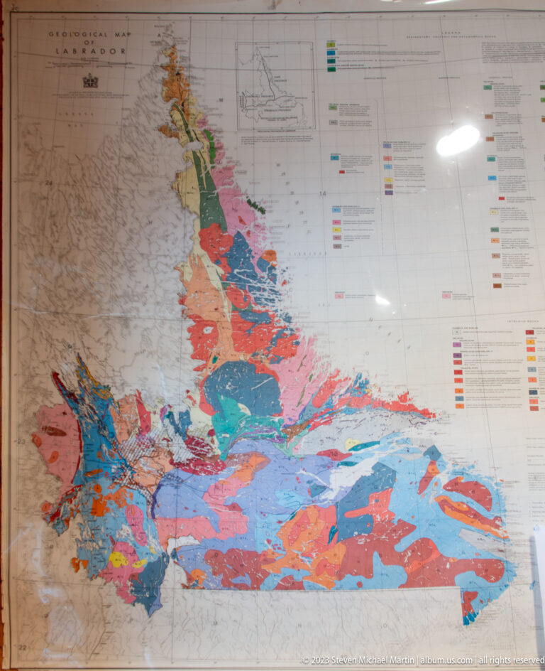 Large framed geological map with many color-coded rock units, technical labels, and a legend along the side.