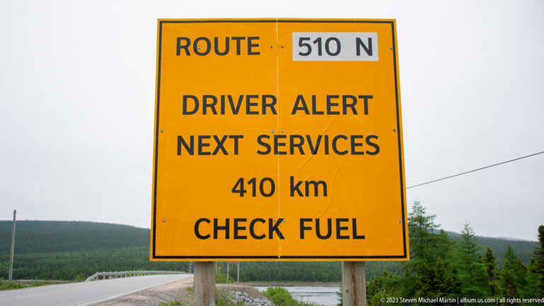Yellow Route 510 North sign reading 'DRIVER ALERT — NEXT SERVICES 410 km — CHECK FUEL.'