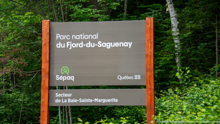 Brown and wood-framed Sépaq sign for Parc national du Fjord-du-Saguenay, Secteur de la Baie-Sainte-Marguerite.