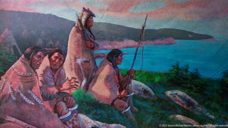 Painted scene of Indigenous people beside a river, including seated figures, a standing fisher, and a conical shelter.