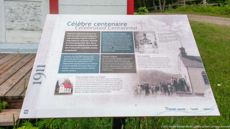 Bilingual “Celebrated Centennial” interpretive panel with historic photographs of the 1911 chapel and community.