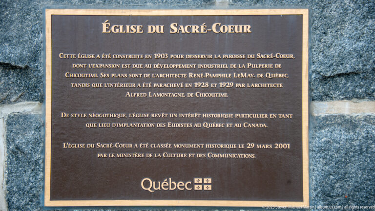Bronze Québec plaque describing the 1903 Église du Sacré-Cœur, its architects, neo-Gothic style, and historic designation.