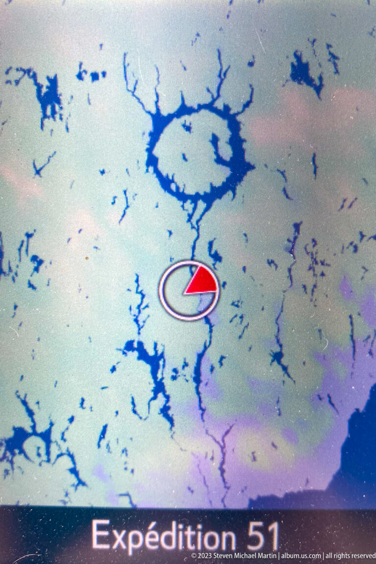 Navigation screen with a red direction arrow over a maze of blue lakes and reservoir inlets.