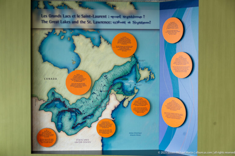 Wall map of eastern Canada and the St. Lawrence region with orange circular text panels and blue coastal waters.