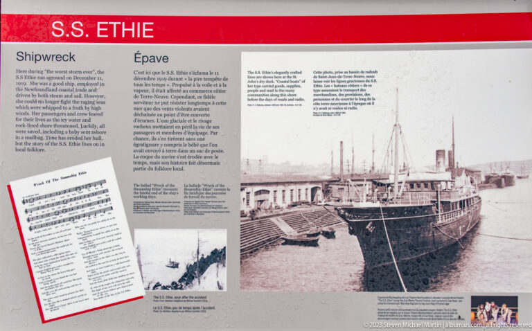 Historic interpretation panel with an archival steamship at a wharf, bilingual text, timetable, and smaller photographs.