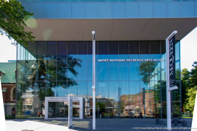Glass entrance of the Musée national des beaux-arts du Québec with museum lettering and Pavillon Pierre Lassonde signage.