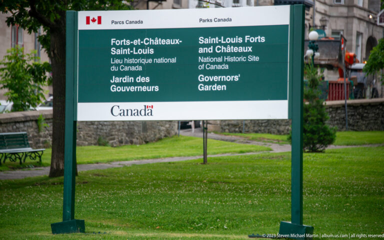 Green bilingual Parks Canada sign naming Saint-Louis Forts and Châteaux National Historic Site and Governors Garden.