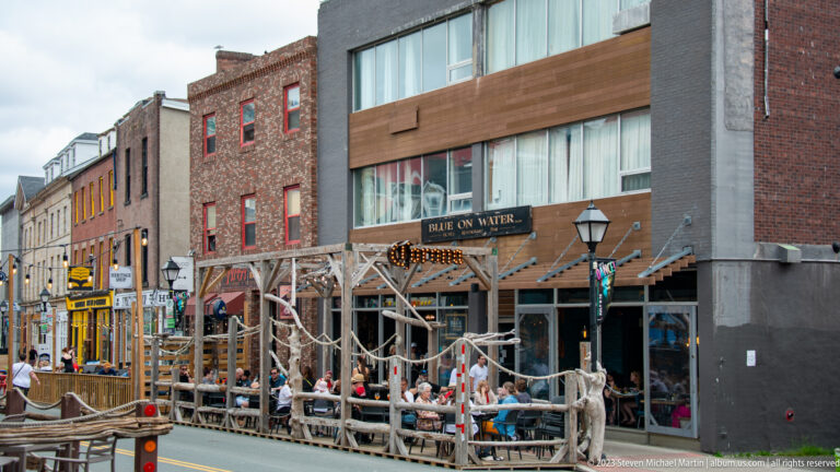 Blue on Water restaurant with diners seated on a rustic timber-and-rope street patio in downtown St. John’s.