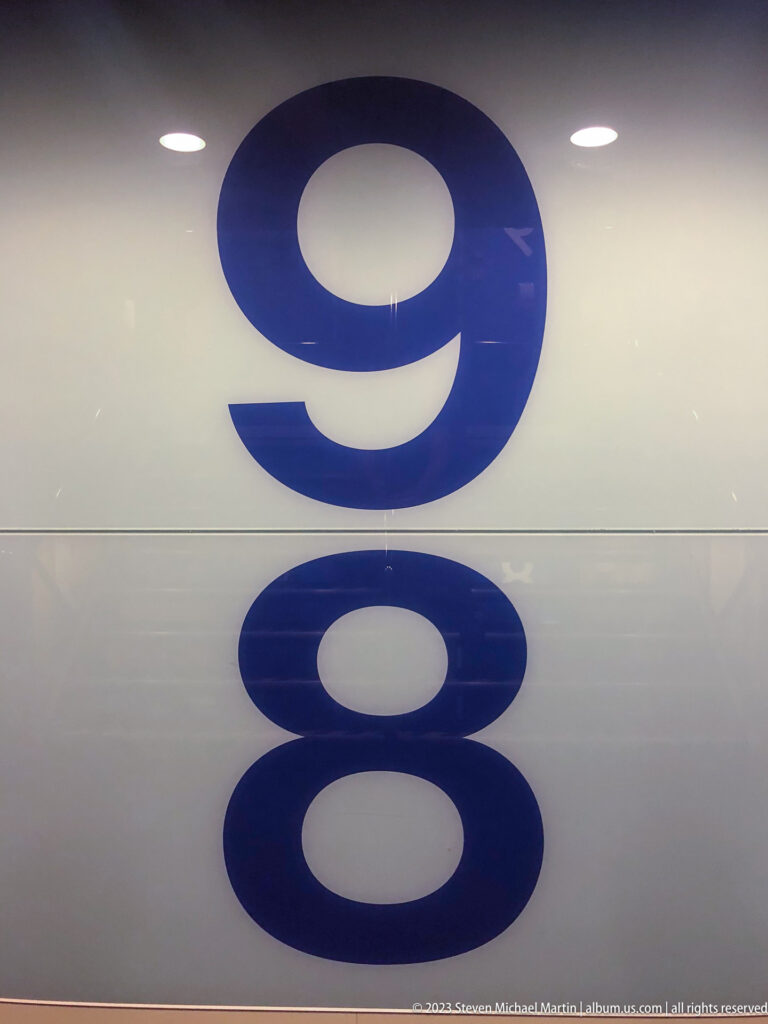 Large blue numerals 9 and 8 arranged vertically on a glossy white ferry bulkhead.