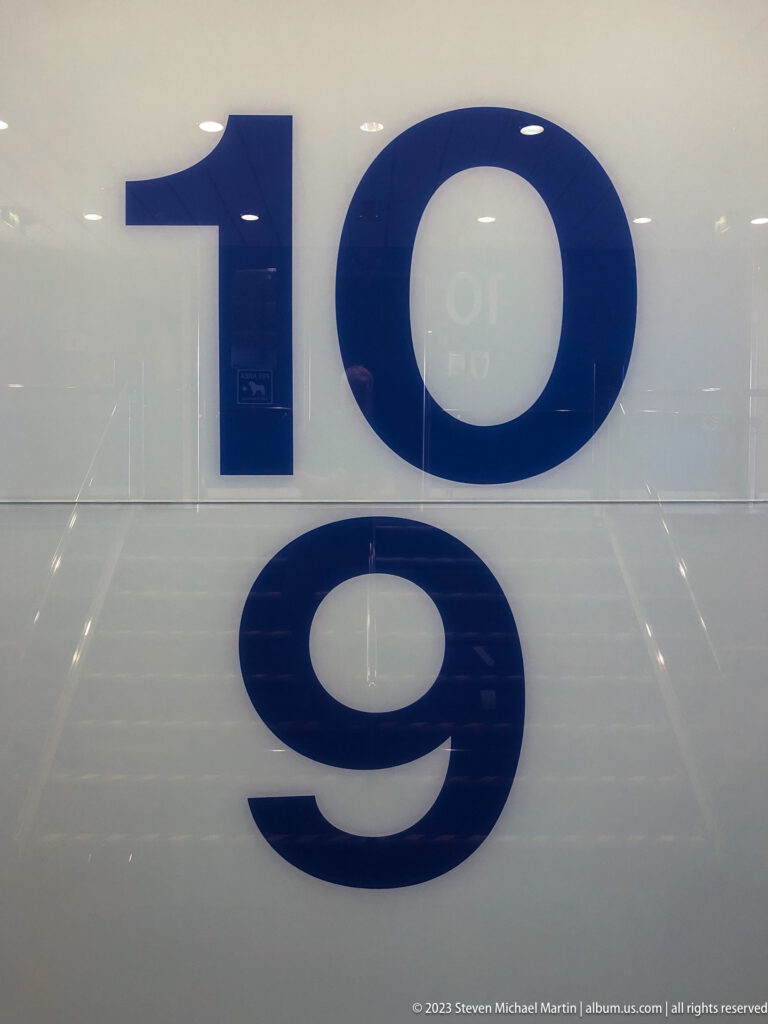 Large blue numerals 10 and 9 arranged vertically on a glossy white ferry interior wall.