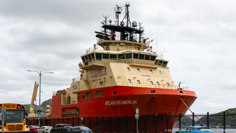 Large offshore support vessel Atlantic Merlin seen from near the bow, with high bridge, antennas, and red lower hull.