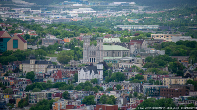 Basilica-Cathedral of St. John the Baptist with twin towers and green roof rising above central St. John’s neighborhoods.