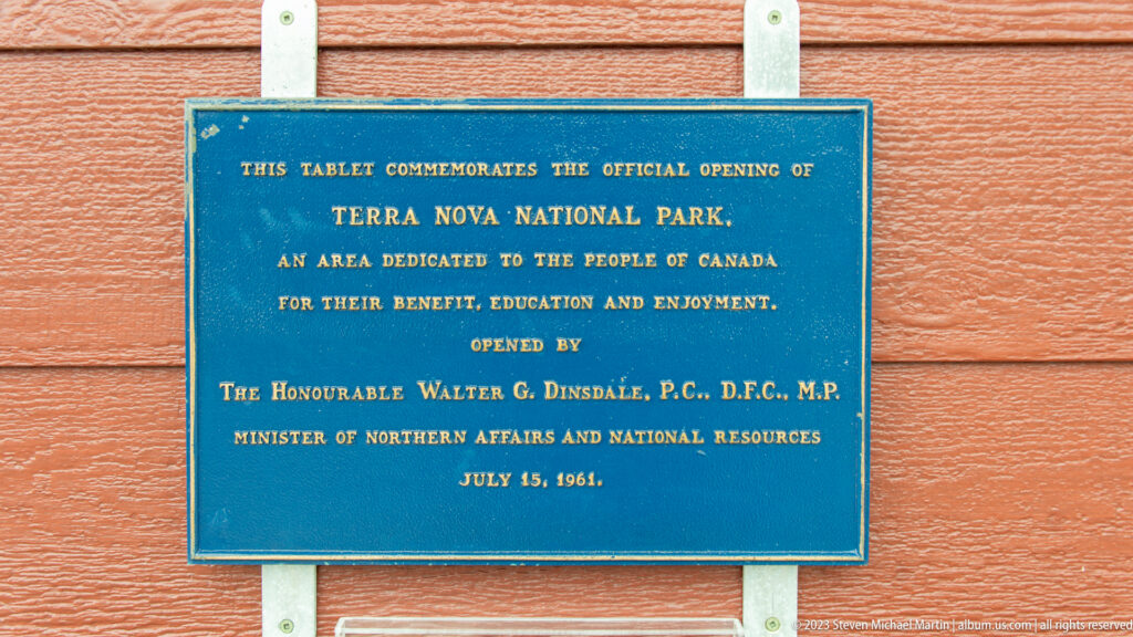 Blue and gold plaque on red siding commemorating the official opening of Terra Nova National Park on July 15, 1961.