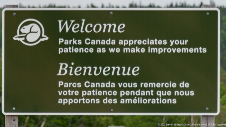 Green bilingual Parks Canada sign asks visitors for patience while improvements are underway.