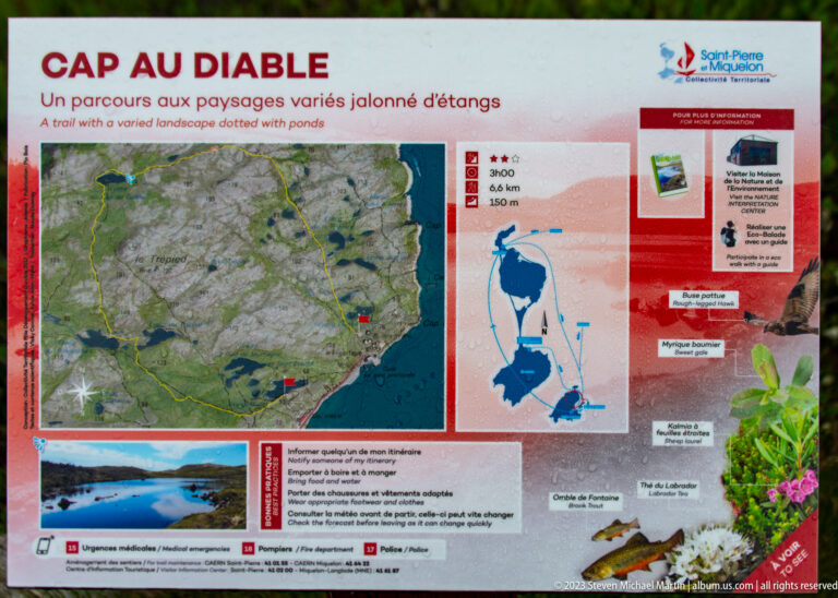 Outdoor bilingual trail information panel with map, route profile, wetland imagery and Saint-Pierre-et-Miquelon branding.