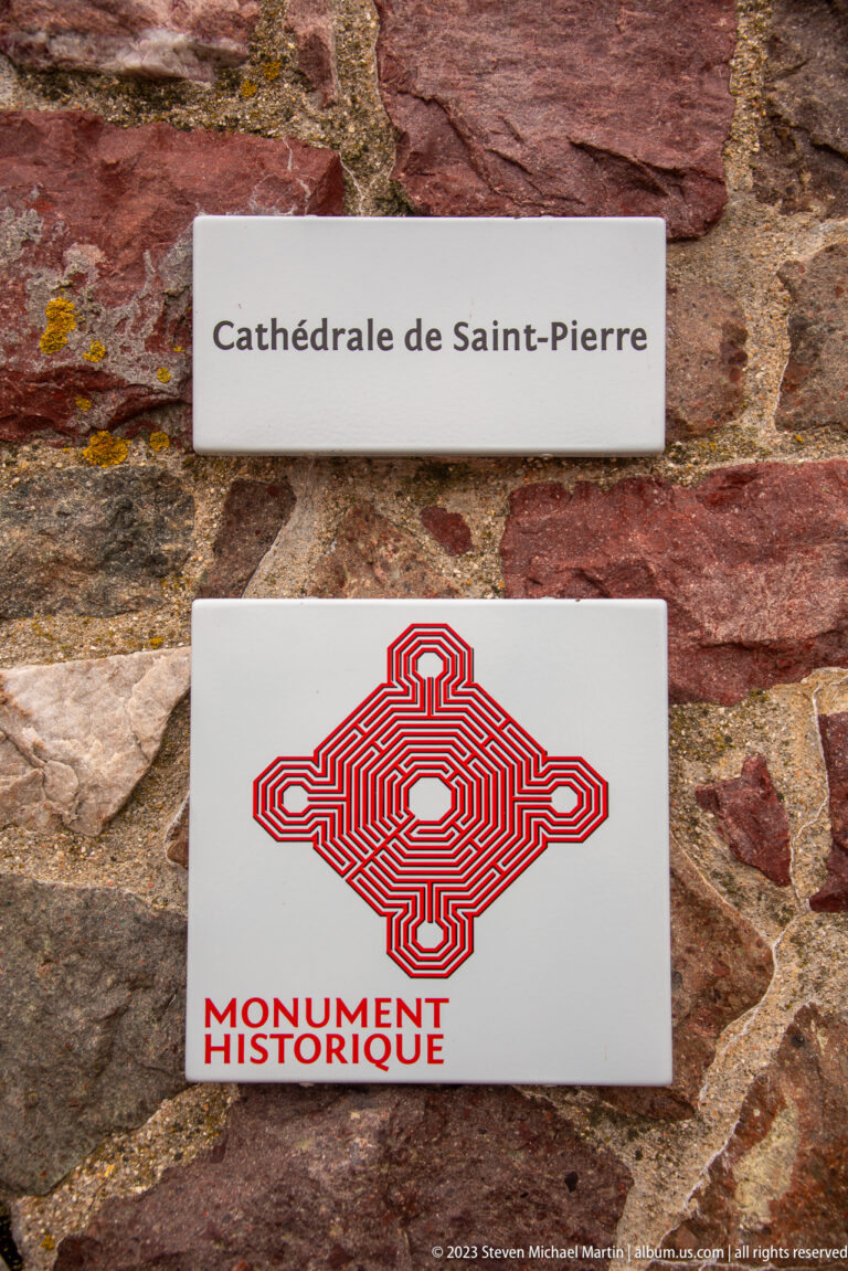 Two plaques on a stone wall read “Cathédrale de Saint-Pierre” and display the red Monument Historique emblem.