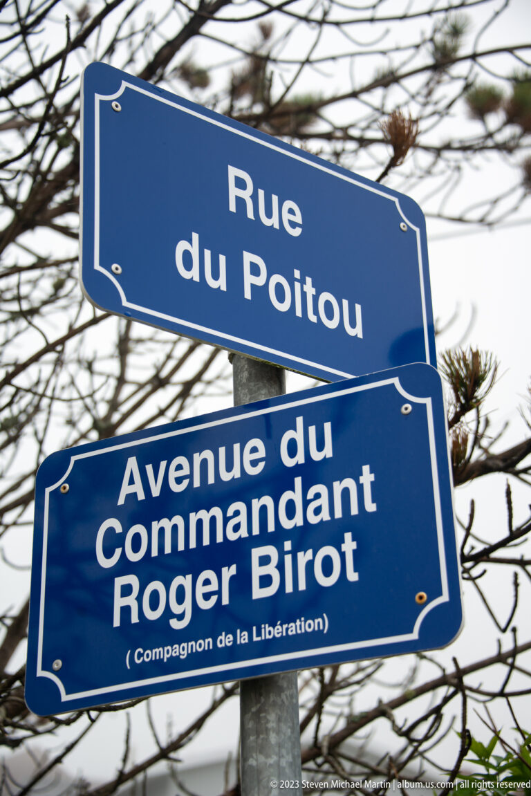 Blue signs for Rue du Poitou and Avenue du Commandant Roger Birot, the latter noting “Compagnon de la Libération.”