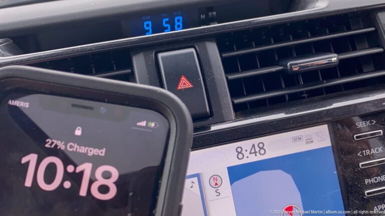 Smartphone showing 10:18 in front of a dashboard where other digital displays read 8:48 and 9:58.