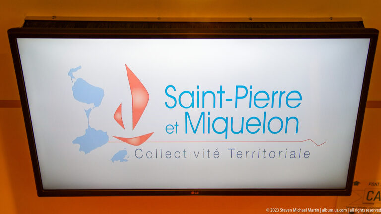 Screen displaying the Saint-Pierre et Miquelon Collectivité Territoriale logo with island silhouettes and a red sailboat.