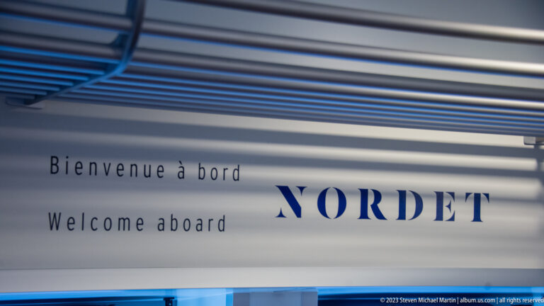 Bilingual Bienvenue à bord and Welcome aboard sign with NORDET lettering inside a passenger ferry.