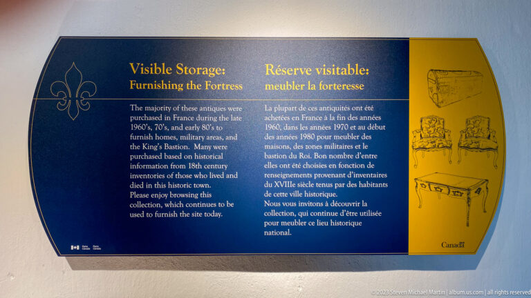 Bilingual blue-and-yellow interpretive panel titled Visible Storage: Furnishing the Fortress with drawings of period furniture.