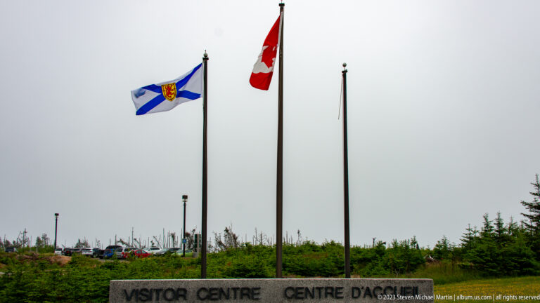 Nova Scotia and Canadian flags flying above the Visitor Centre entrance sign.