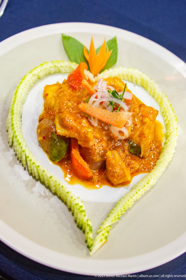 Prepared Cambodian entrée served on a white plate with decorative garnish.
