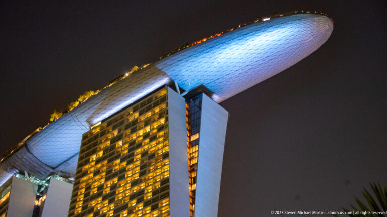 Two Marina Bay Sands towers beneath the curved, illuminated underside of the rooftop SkyPark.