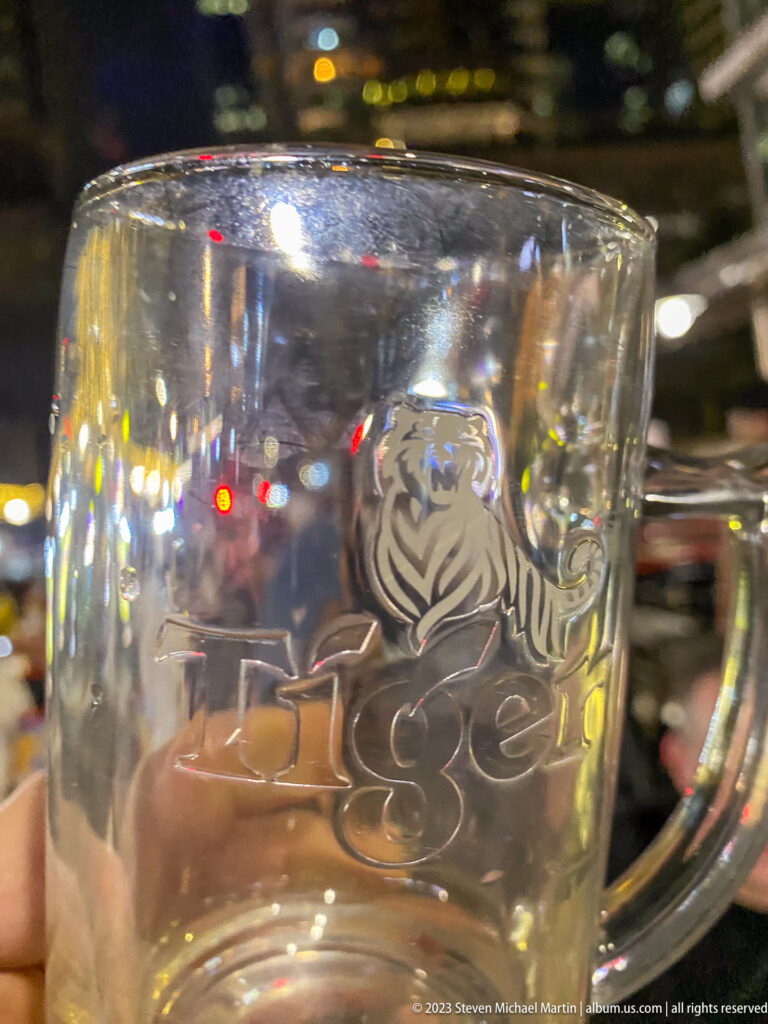 Close view of an empty glass mug embossed with the Tiger beer logo.
