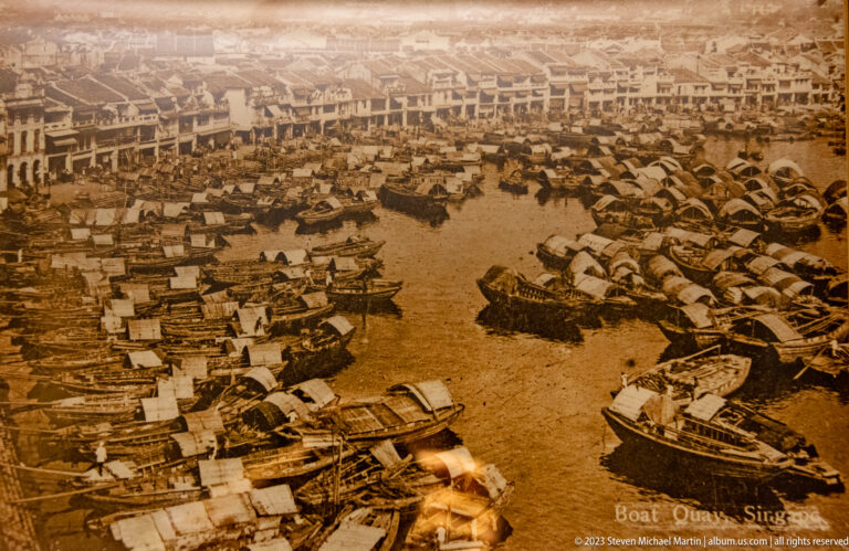 Sepia historic view of Boat Quay crowded with small boats and waterfront buildings.