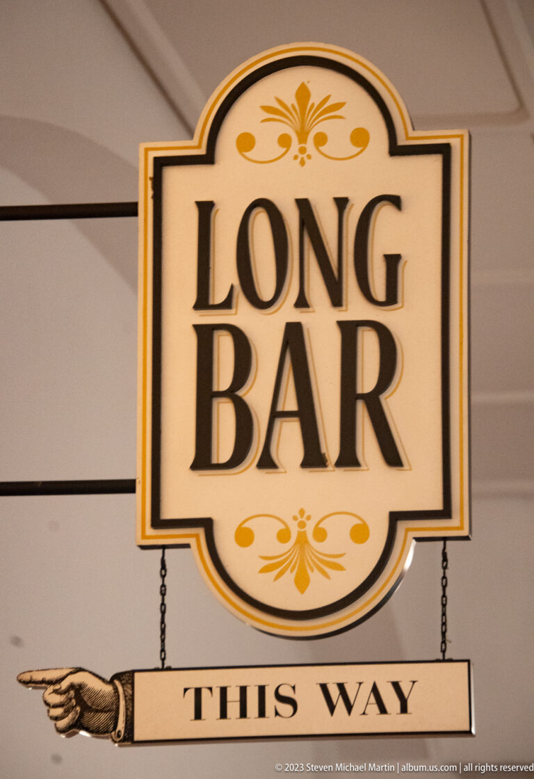 Decorative Long Bar sign with a pointing hand and the words This Way.