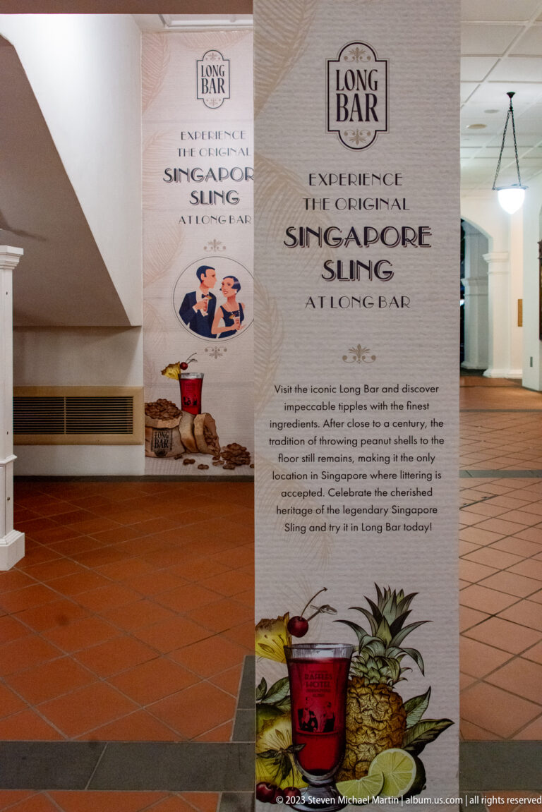 Long Bar promotional display advertising the Original Singapore Sling with cocktail and pineapple images.
