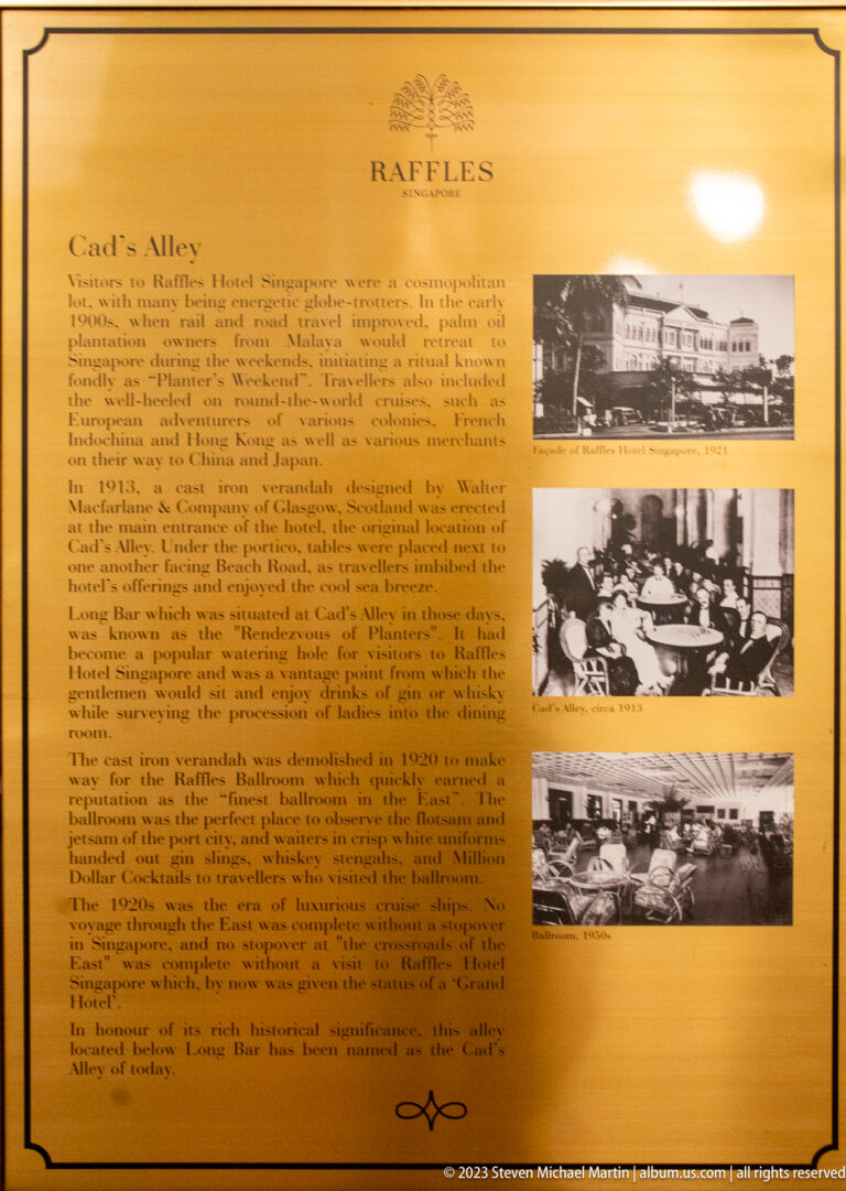 Illuminated Raffles interpretive panel with text and historic photographs about the Long Bar.