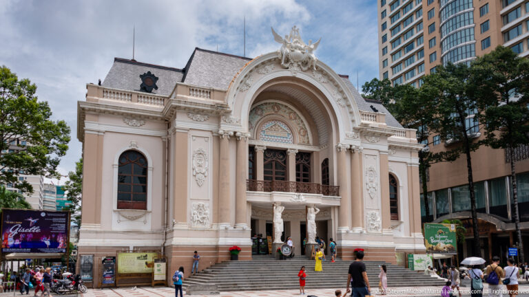 Ornate cream façade of the Saigon Opera House with steps, pedestrians, and towers.
