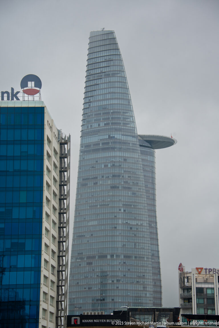 Close view of Bitexco Financial Tower showing its tapered glass form and projecting helipad.