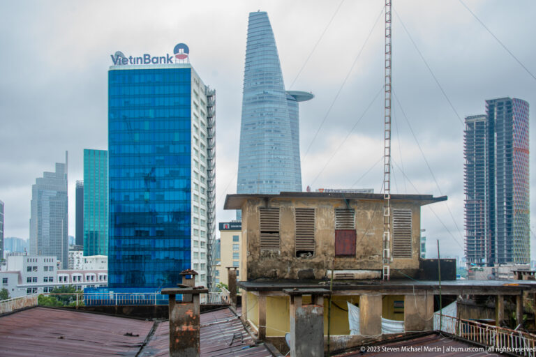 Weathered rooftop structure beneath the Bitexco Financial Tower and neighboring glass high-rises.