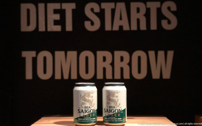 Two Bia Saigon Lager cans below large blurred words, “It starts tomorrow.”