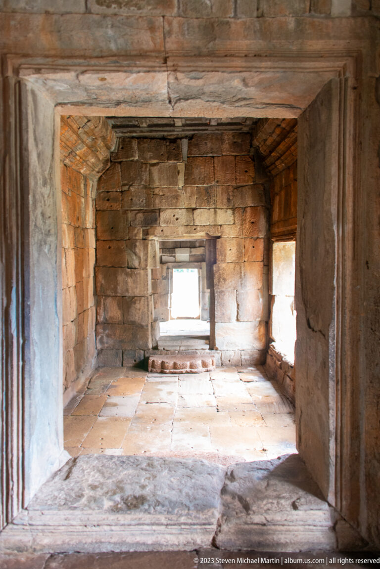 Long narrow stone corridor with bright openings at both ends at Angkor Thom.
