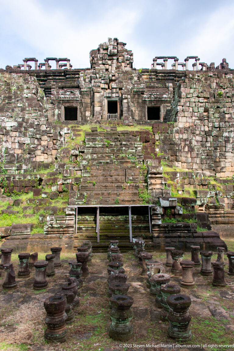 Steep moss-covered stair climbing a broad stone façade at Angkor Thom.
