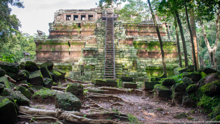 Moss-covered stepped brick platform with narrow central stair at Angkor Thom.