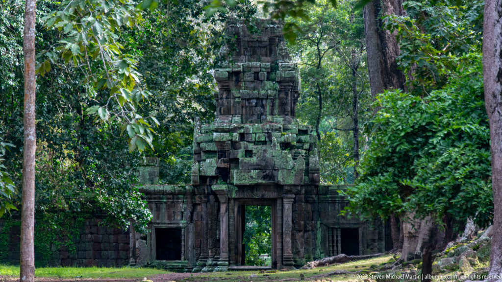 Tall narrow gopura framed by dense forest at Angkor Thom.